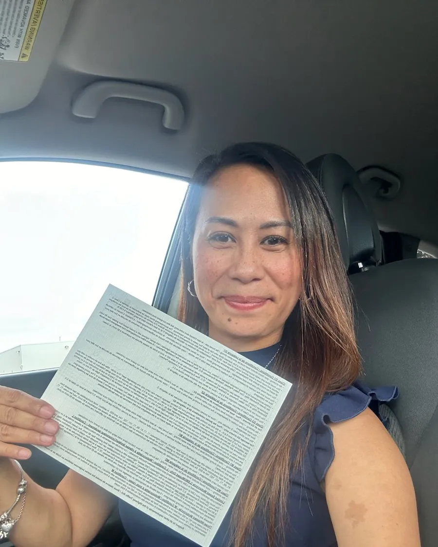 Student in the car holding the paperwork from their road test