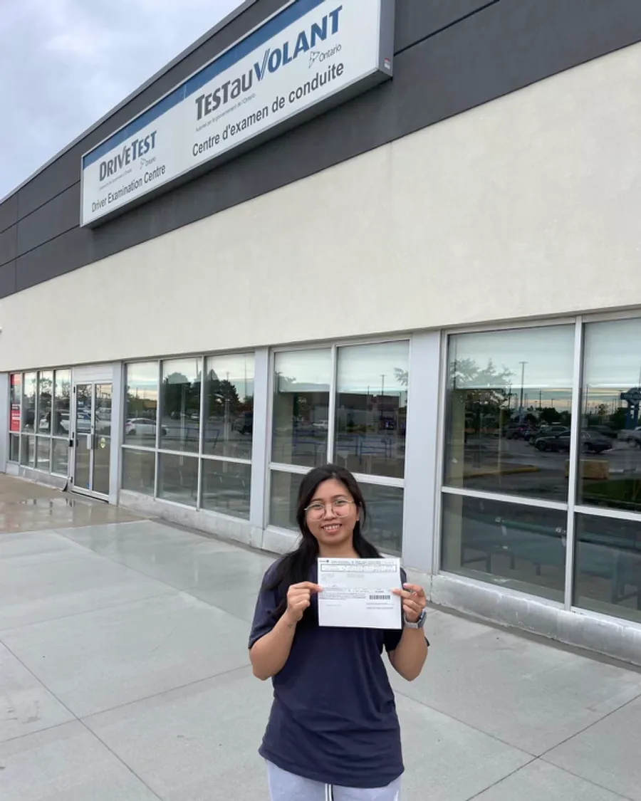 Student outside the DriveTest centre, holding their road test result